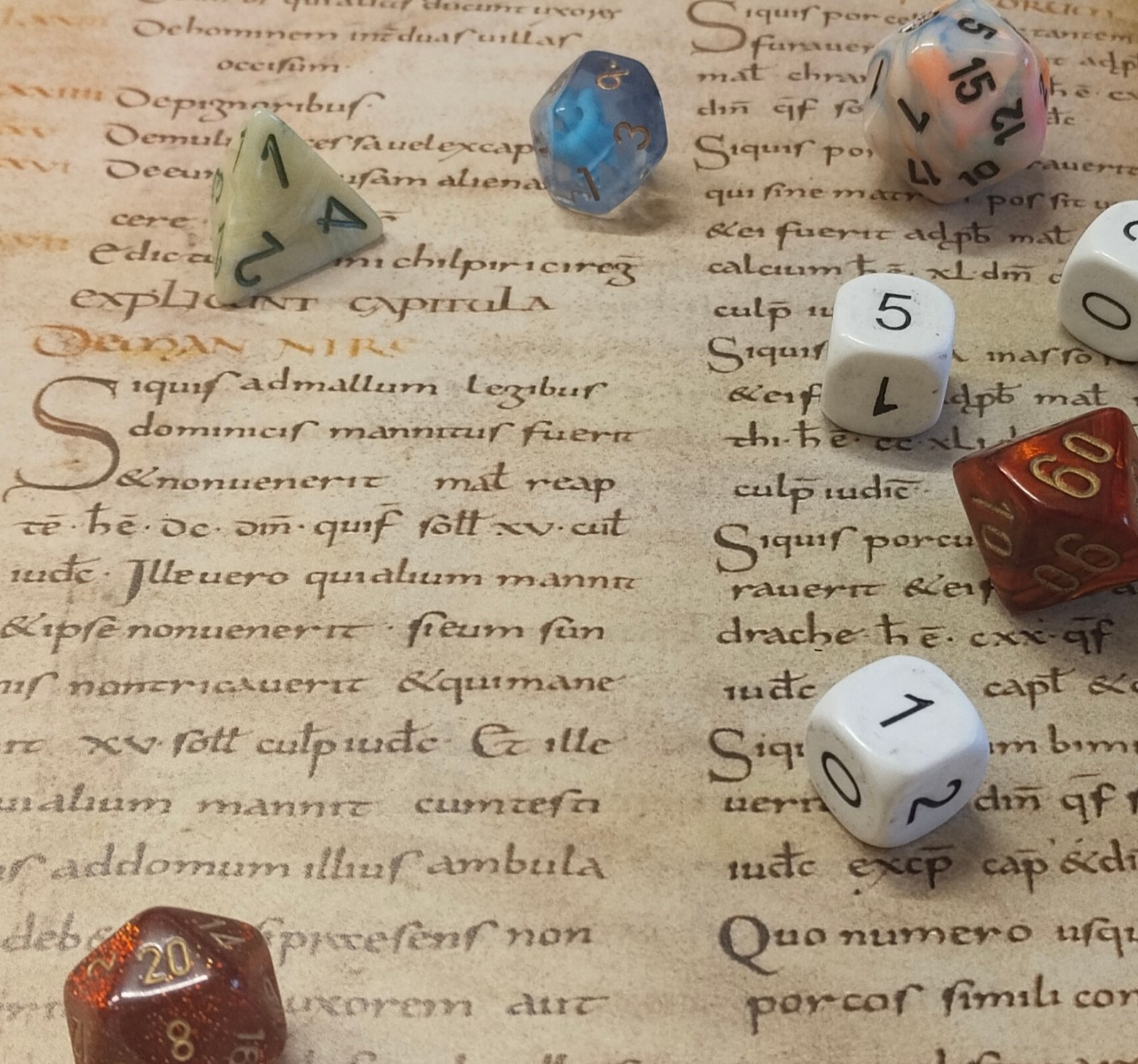 A handful of polyhedral dice lay scattered across a section of an early medieval law-book, specific fol. 180v of the early-ninth century copy of the Pactus Legis Salicae: Paris, Bibliothèque Nationale de France, MS Lat. 4404. Used with kind permission of BNF-Gallica (2026).